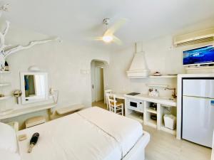 a white room with a bed and a desk at Deluxe Studios & Suites Ageri-Milos in Adamantas