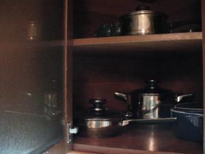 a shelf with pots and pans in a kitchen at Apartments near POLITECH in Kyiv
