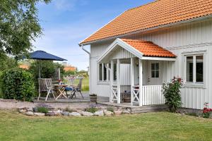 uma pequena casa branca com uma mesa e um pátio em Villa Tjurpannan Grebbestad em Grebbestad