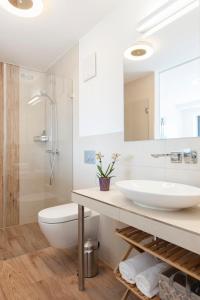 a white bathroom with a sink and a shower at Haus Verando - Apartment Meeresrauschen II in Binz