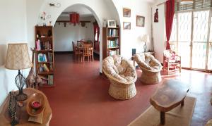 a living room with two chairs and a table at Alison & Dave's Guesthouse in Entebbe