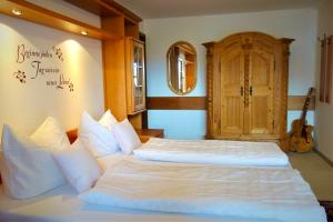 a bedroom with two beds and a wooden door at Ferienwohnungen Keiß in Fischen