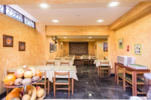 ein Esszimmer mit Tischen und Stühlen und ausgestelltem Obst in der Unterkunft Hotel Botanico in Lissabon