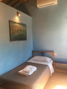 een bed in een kamer met een schilderij aan de muur bij Colle dei Falchi in Fermo