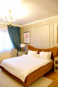 コンスタンツァにあるSeaside Luxury Apartamentのベッドルーム(シャンデリア付きの白い大型ベッド1台付)