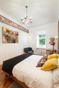 um quarto com uma grande cama branca e um lustre em Gallery Art Apartment em Lviv