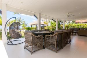 a dining room with a table and chairs on a patio at Malee Beach A4 in Ko Lanta