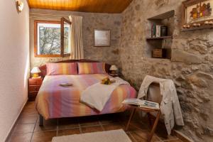 a bedroom with a bed and a table with a book at La Batllia in Sant Joan de les Abadesses