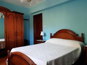 1 dormitorio con cama y pared azul en Casa Entremolin, en Belmonte de Miranda