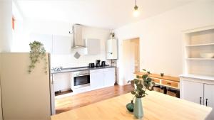 a kitchen with white appliances and a wooden floor at Zentral Wohnen - inkl. privatem Stellplatz in Würzburg