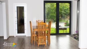 a dining room table and chairs in front of a door at 4 Seasons - House in Sub Cetate