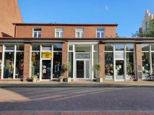 a brick building with windows and doors on a street at Inselkern Einraum-Apartments in Juist