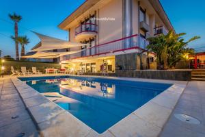 a swimming pool in front of a building at Eden Charming House in Avola