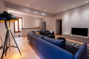 uma sala de estar com um sofá azul e uma televisão de ecrã plano em La casa dell’artista em Assis
