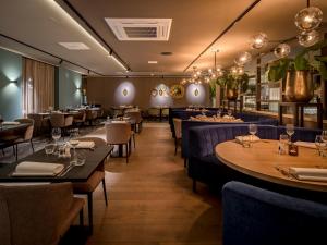 a restaurant with tables and chairs in a room at Grenshotel de Jonckheer in Ossendrecht