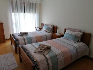 1 dormitorio con 2 camas y ventana en Apartamento T3 Amorosa, en Viana do Castelo