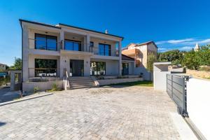 a large white house with a driveway at Villa Munat in Ližnjan