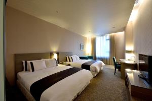 Postel nebo postele na pokoji v ubytování Shinkansen Grand Hotel