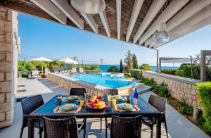 a patio with a table and chairs and a swimming pool at Villa CostaMare - enjoy lazy days on the private Pool-Jacuzzi in Pefki Rhodes