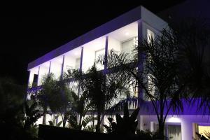 a building lit up at night with blue lights at JOY Hotel Apts in Ayia Napa