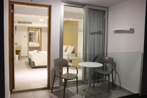 um quarto com uma mesa e cadeiras e um quarto em JOY Hotel Apts em Agia Napa