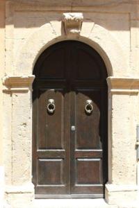une grande porte en bois avec une arche dans un bâtiment dans l'établissement Casa P&G, à Niscemi