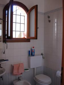 a bathroom with a toilet and a sink and a window at Casa P&G in Niscemi