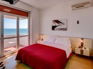 a bedroom with a large bed with a view of the ocean at Hotel Europa in Senigallia