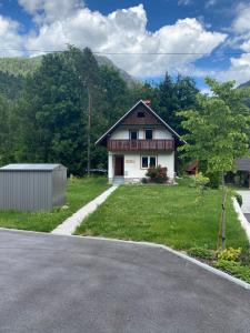 une maison assise sur le côté d'une route dans l'établissement Sobe v Gozdu, à Gozd Martuljek