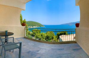 a balcony with a table and a view of the water at Fedra Apartments in Poros