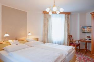 Postel nebo postele na pokoji v ubytování Gasthof Hametner mit Innviertlerhof mit direktem Zugang zur Therme Mediterrana durch unseren Garten!