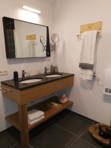 a bathroom with two sinks and a mirror and towels at Elingenhof in Elingen