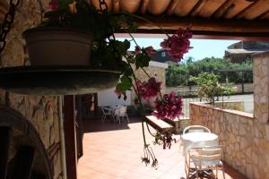 a patio with flowers hanging from a stone wall at B&B La Vigna in Lamezia Terme