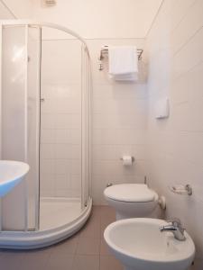 a bathroom with a shower and a toilet and a sink at Hotel Europa in Senigallia