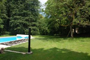 een tuin met een zwembad en een boom bij Gites Chateau le Bois in Saint-Julien-aux-Bois