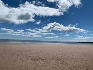 una playa con un cielo nublado y el océano en Grey Harlings Hotel, en Montrose