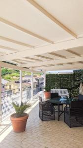 a patio with a table and chairs on a roof at Ampio attico a 5 minuti dal mare in San Benedetto del Tronto