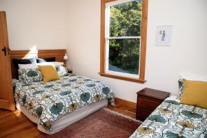 um quarto com uma cama e uma janela em Elegant Villa Nestled In The Trees em Nelson