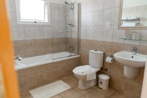 a bathroom with a toilet and a sink and a tub at Agia Thekla Villa Ekaterina 4 bdrm in Ayia Napa