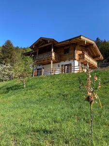 una casa de madera en una colina con un campo verde en Ferienhaus Berggfui en Berchtesgaden