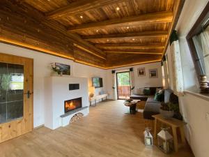 uma sala de estar com tectos em madeira e uma lareira em Ferienhaus Berggfui em Berchtesgaden