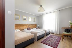 una camera con 3 letti e un tappeto di Majątek Howieny "Sielanka" 