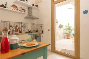 a kitchen with a table with a plate of food at Barocco House in Vernole