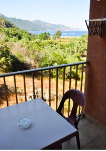 una mesa blanca y una silla en un balcón con vistas en Résidence Stella Marina, en Serriera