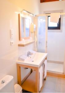 a white bathroom with a sink and a toilet at Résidence Stella Marina in Serriera