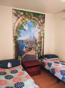 ゲレンジークにあるGuesthouse U Dmitriaの壁に壁画が飾られた客室で、ベッド2台が備わります。