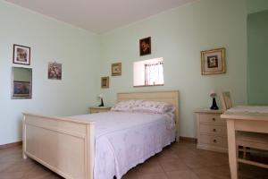 a bedroom with a bed and a dresser and a window at Case Vacanze La Venere in Rocca Imperiale