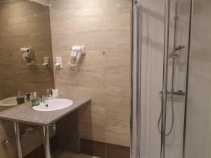 ein Bad mit einem Waschbecken und einer Dusche in der Unterkunft Hotel Relax in Słubice