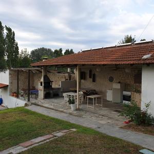 a house with an outdoor patio with a grill at Amparoudes in Kriopigi