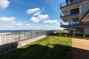 widok na plażę z balkonu budynku w obiekcie Apartamenty Gardenia Seaside by Noclegi Renters w Dziwnowie